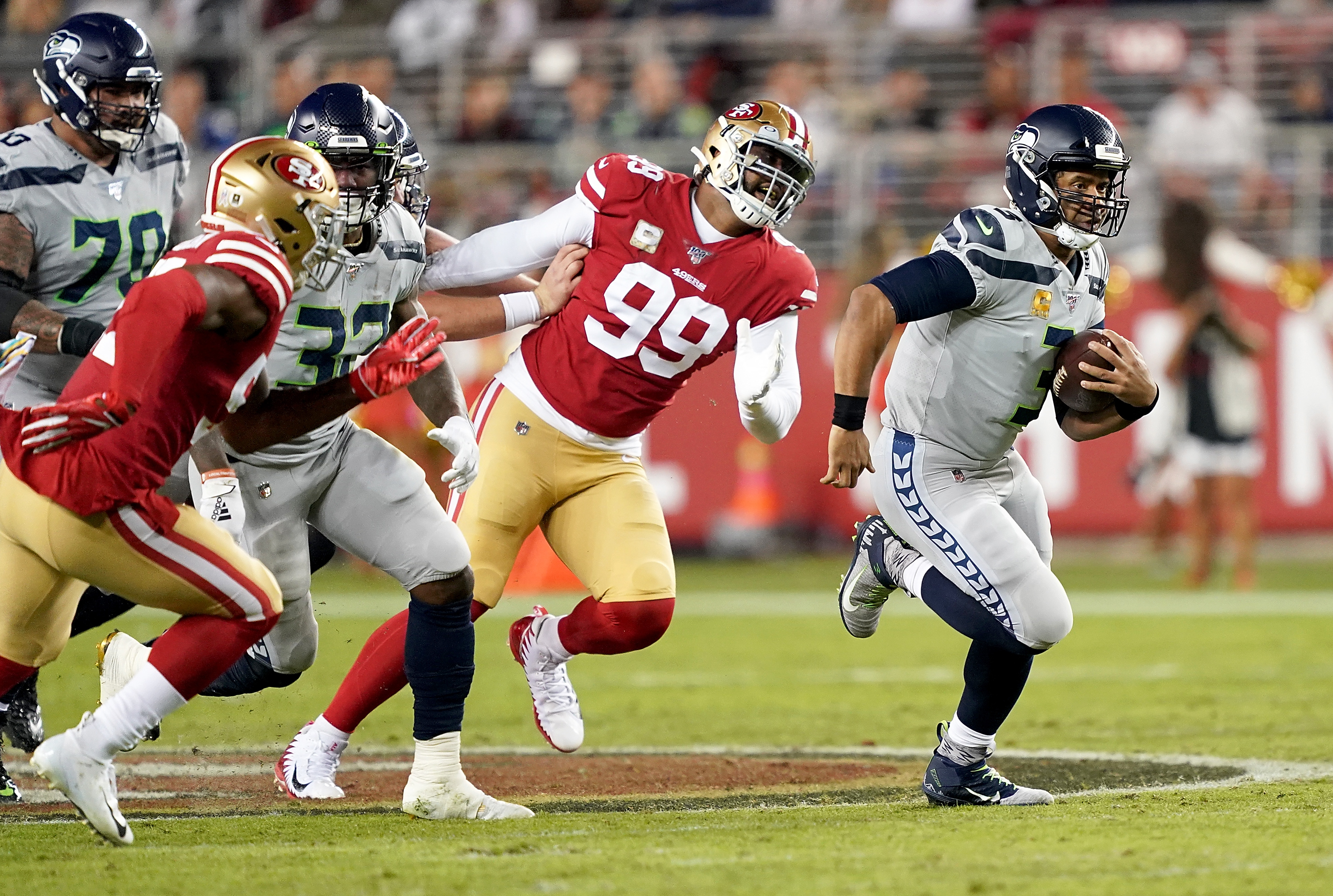 Quarterback Russell Wilson of the Seattle Seahawks scrambles against the defense of the San Francisco 49ers. (Photo by Thearon W. Henderson/Getty Images)