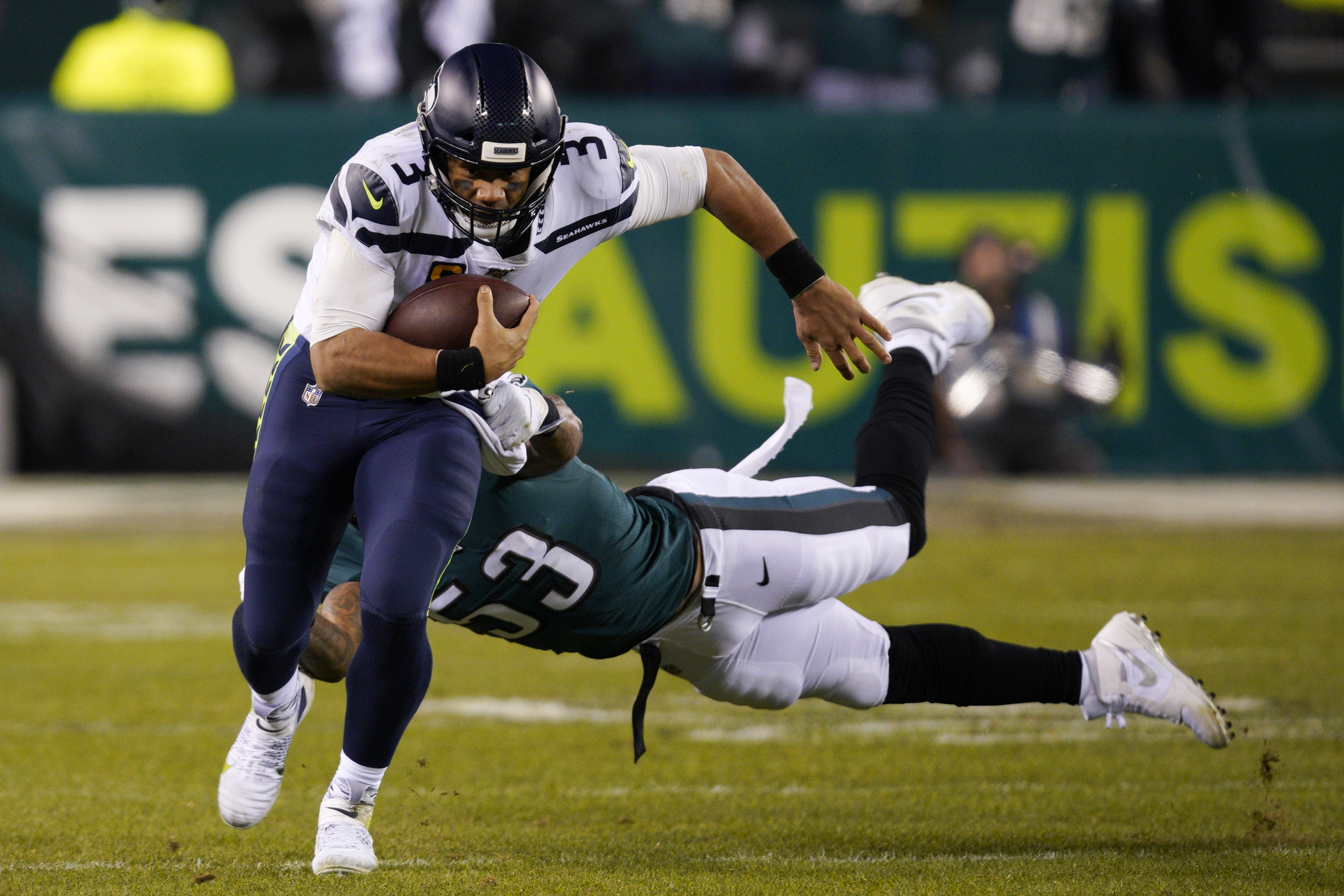Seahawks quarterback Russell Wilson (3) rushes past Philadelphia's Nigel Bradham on Sunday. (AP Photo/Chris Szagola)