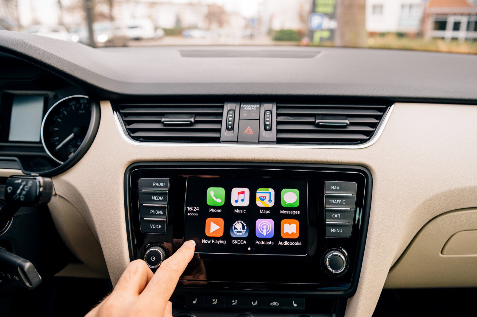 PARIS, FRANCE - DEC 13, 2016: Man pressing home button on the Apple CarPlay main screen in modern car dashboard. CarPlay is an Apple standard that enables a car radio or head unit to be a display and controller for an iPhone. It is available on all iPhone 5 and later with at least iOS 7.1.