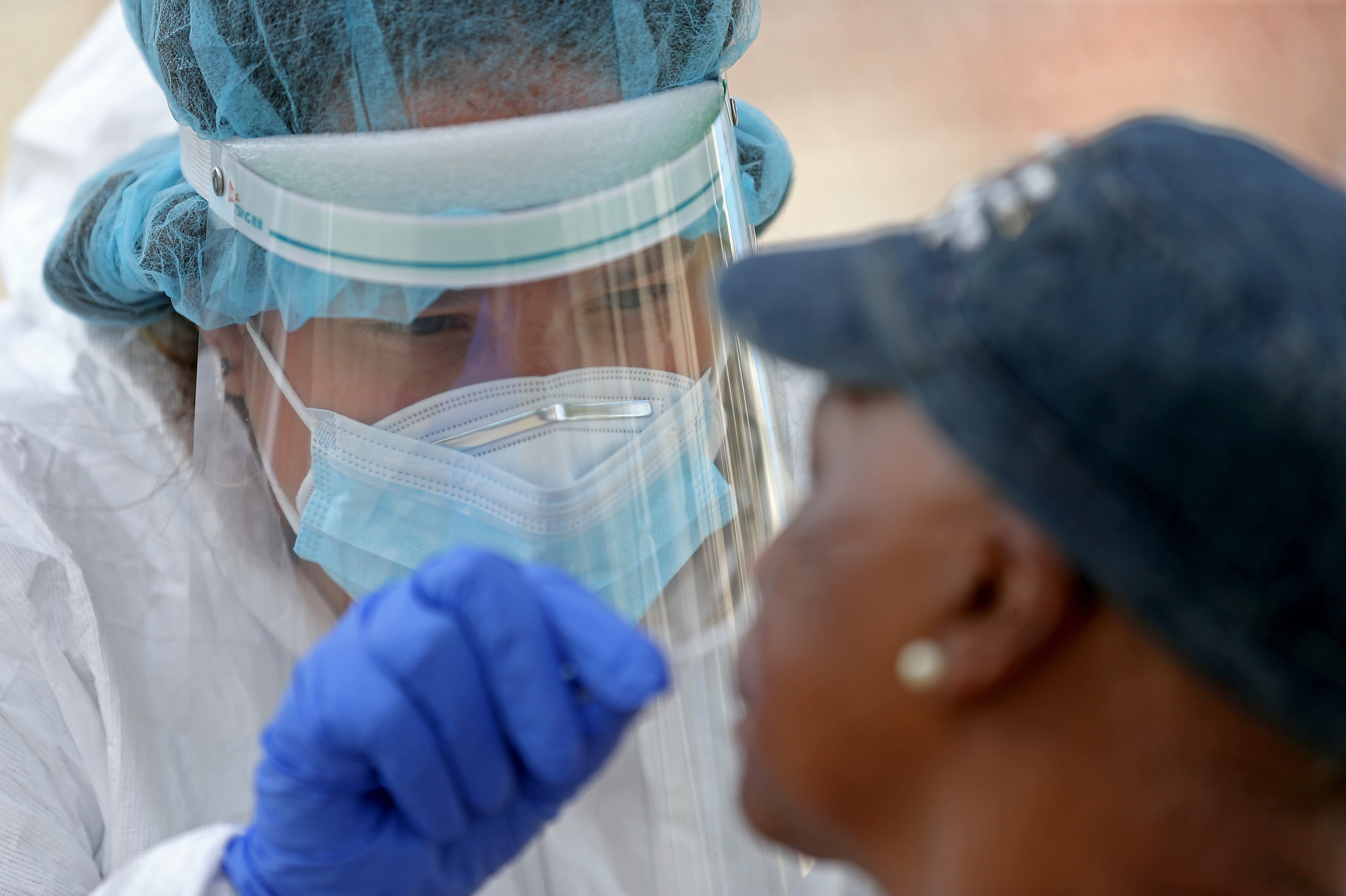 Krystal Rumenos an RN with the Whittier Street Health Center performs a COVID-19 test in the parking lot of Prince Hall Grand Lodge on August 3, 2020 in Roxbury, Massachusetts. (Matt Stone/ MediaNews Group/Boston Herald via Getty Images)