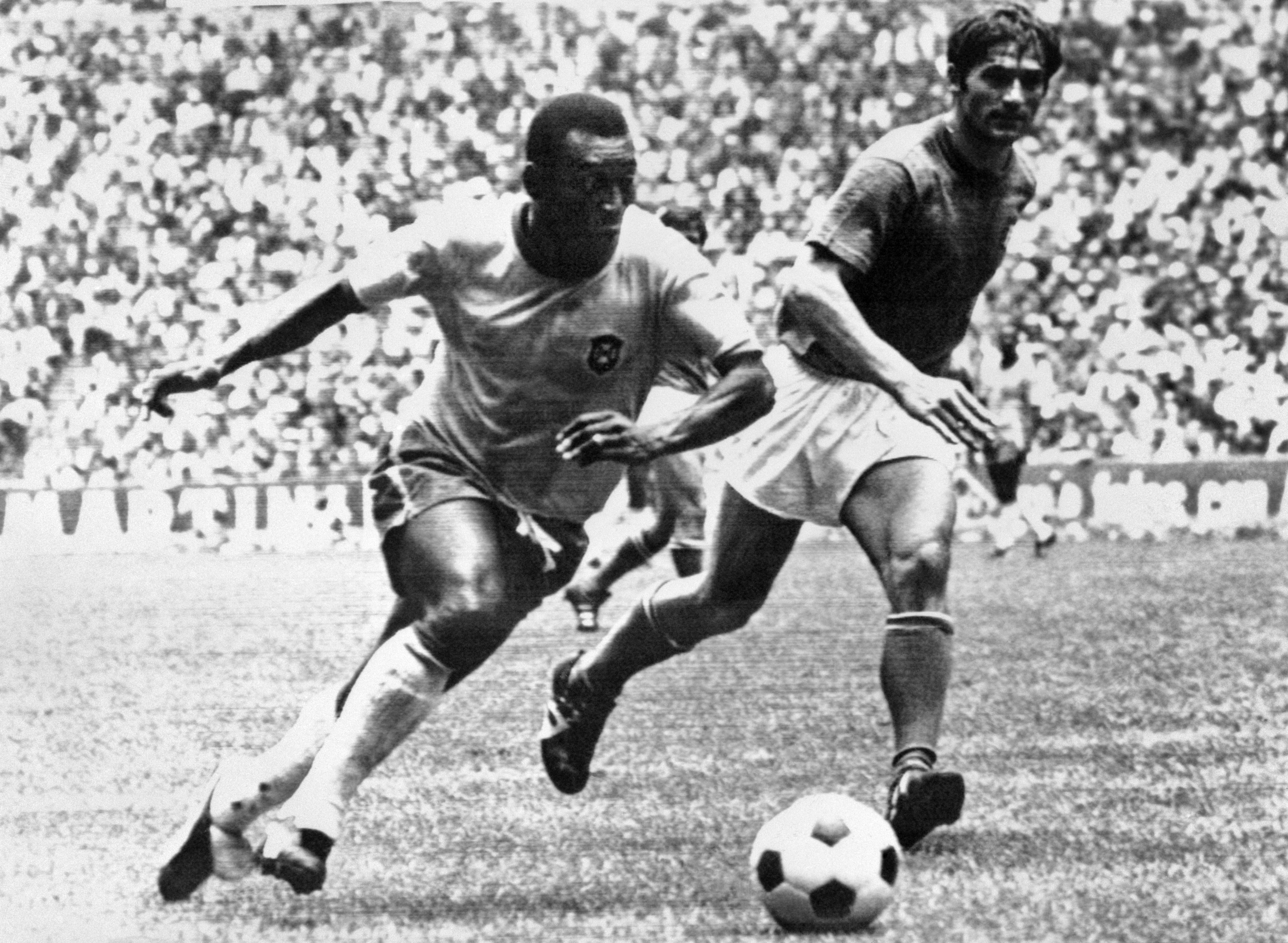 Brazilian midfielder Pelé (L) dribbles past Italian defender Tarcisio Burgnich during the World Cup final on 21 June 1970 in Mexico City. Pelé scored the opening goal for his team as Brazil went on to beat Italy 4-1 to capture its third World title after 1958 (in Sweden) and 1962 (in Chile). (Photo by STAFF / AFP) (Photo by STAFF/AFP via Getty Images)