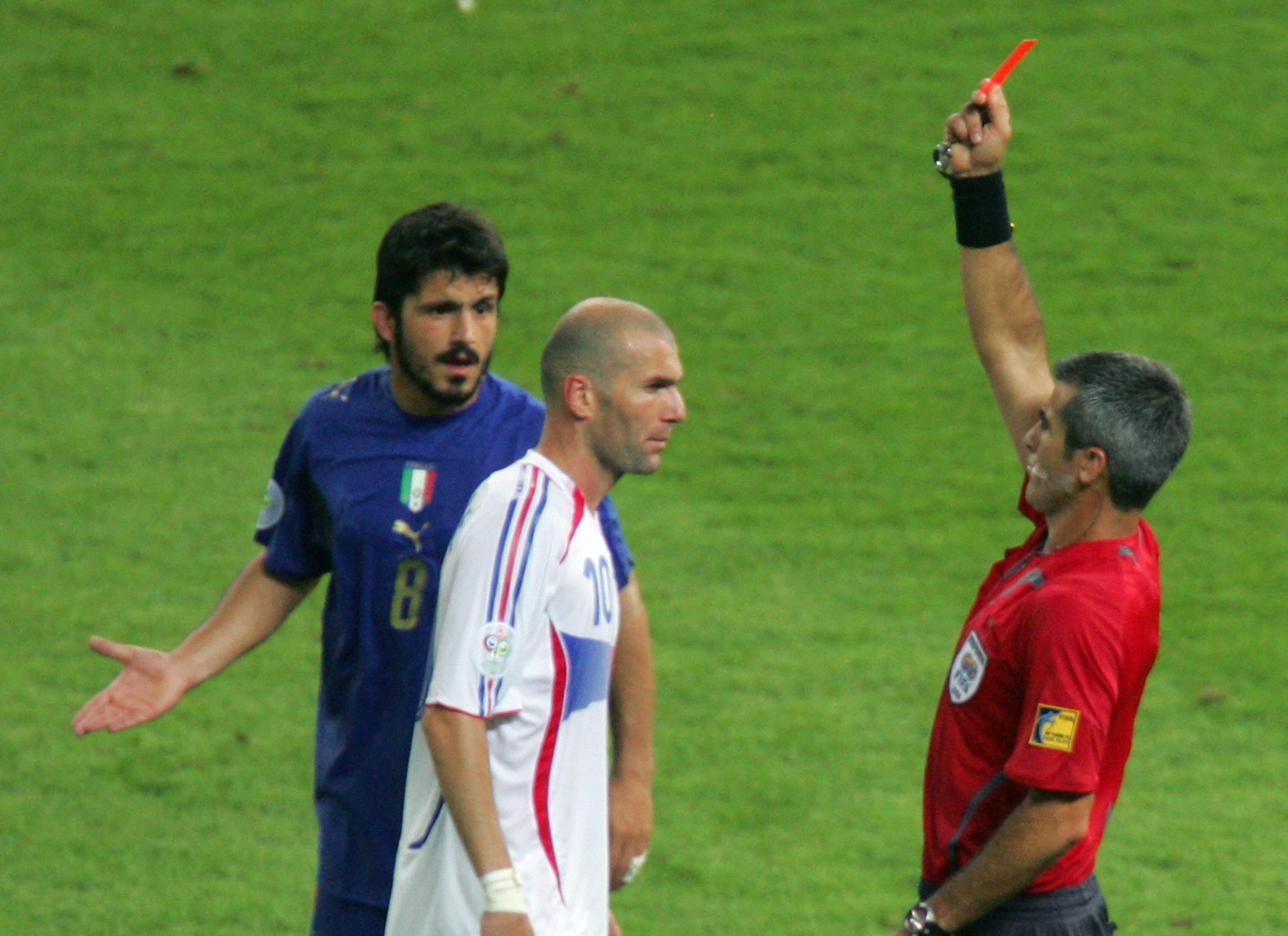 Berlin, GERMANY:  French midfielder Zinedine Zidane (C) receives a red card from referee Horacio Elizondo of Argentina (R) for head-butting Italian defender Marco Materazzi in extra time as Italian midfielder Gennaro Gattuso (L) looks on during the World Cup 2006 final football match between Italy and France at Berlin's Olympic Stadium, 09 July 2006.       AFP PHOTO / ROBERTO SCHMIDT  (Photo credit should read ROBERTO SCHMIDT/AFP via Getty Images)