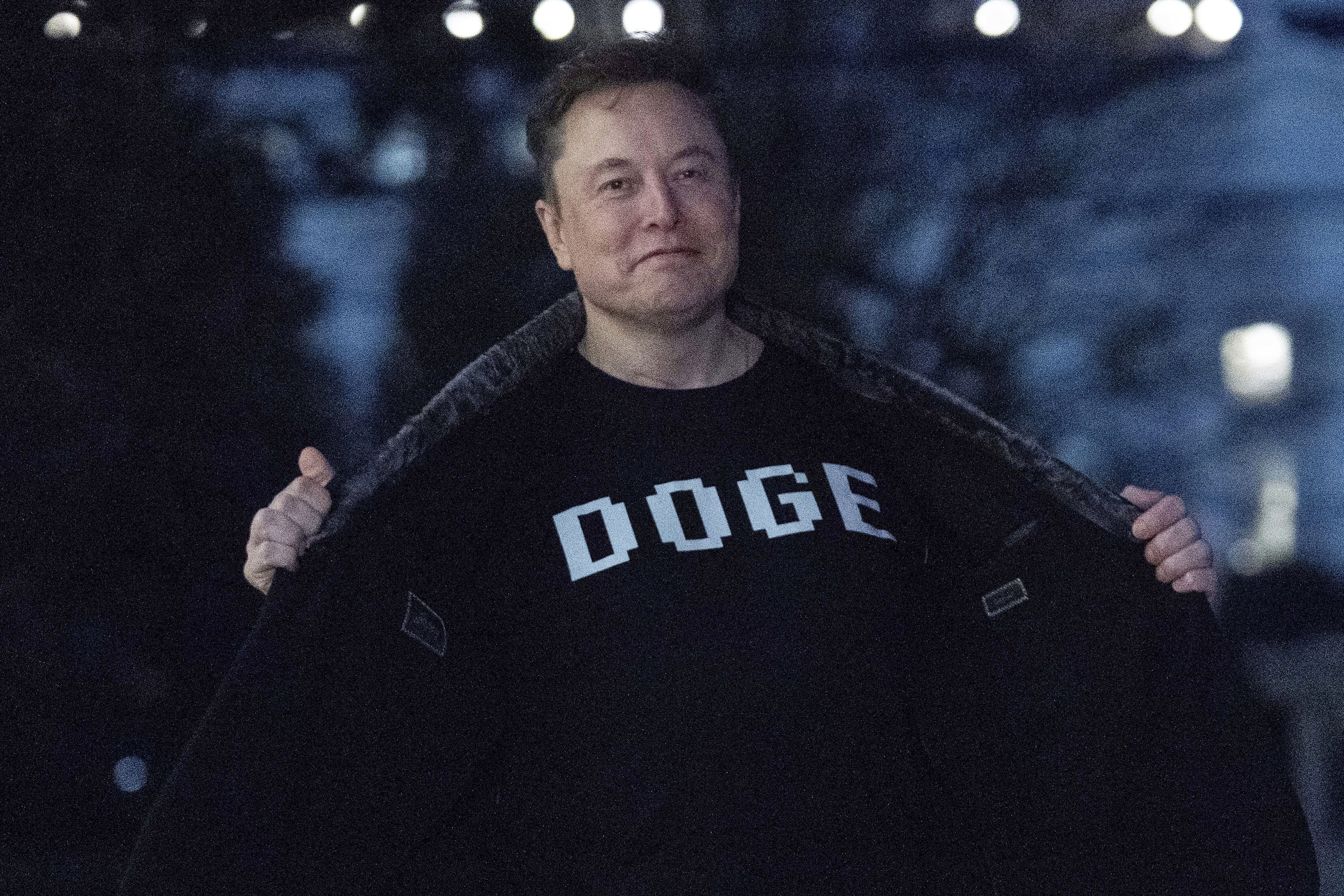 Elon Musk flashes his T-shirt that reads 