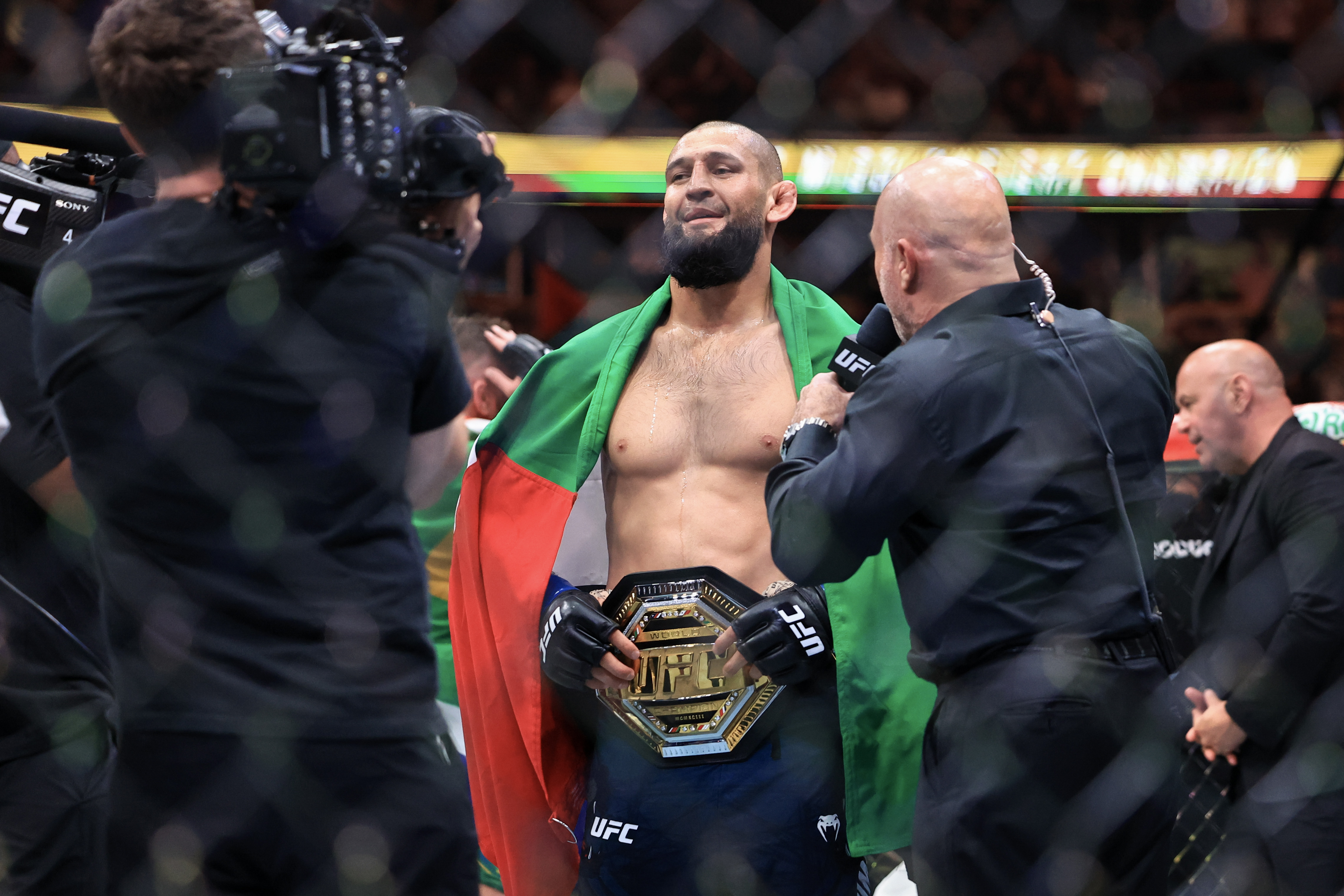 CHICAGO, ILLINOIS - AUGUST 16: Joe Rogan talks to Khamzat Chimaev of the United Arab Emirates after his middleweight title bout victory in UFC 319 at the United Center on August 16, 2025 in Chicago, Illinois. (Photo by Geoff Stellfox/Getty Images)