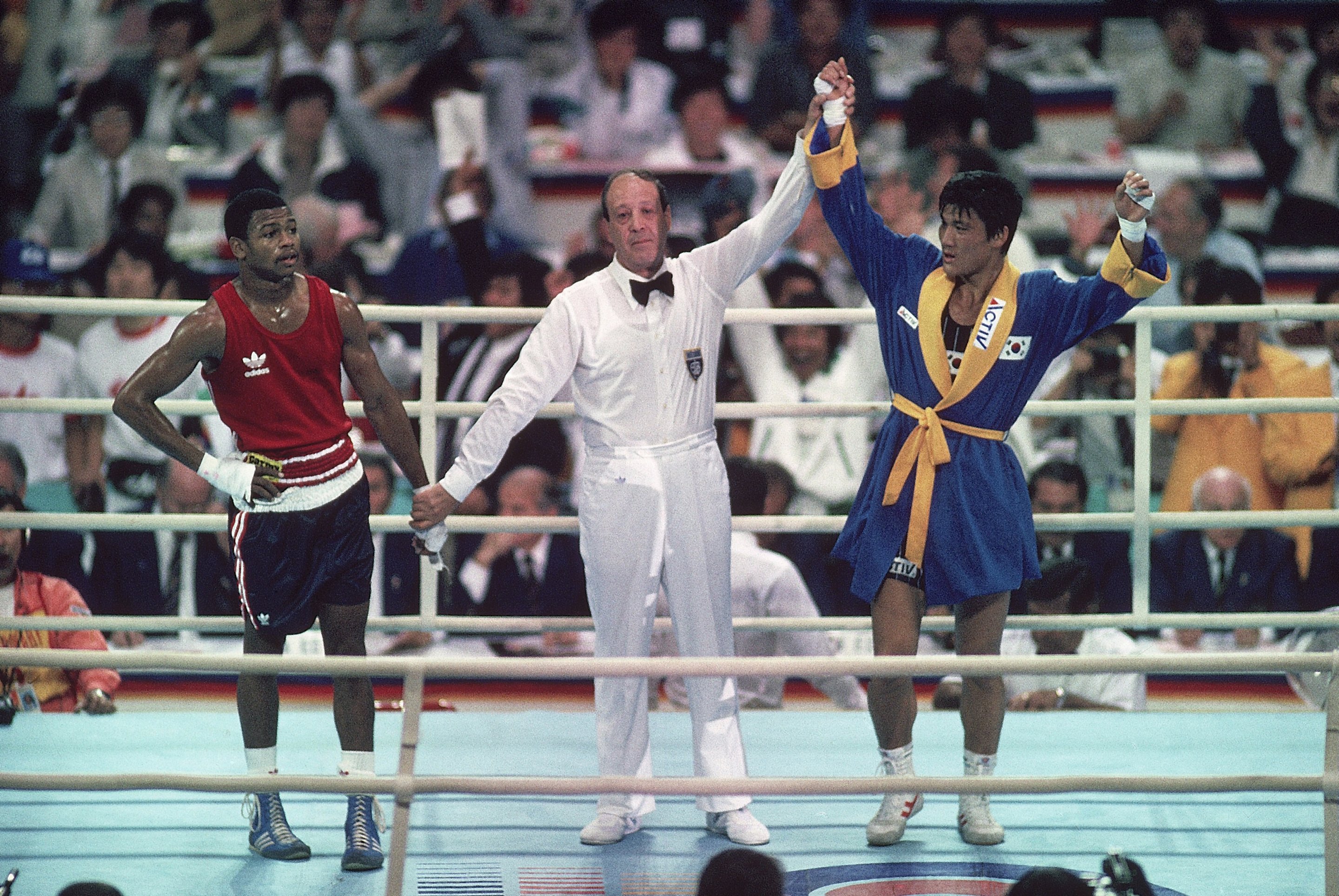 Boxing: 1988 Summer Olympics: Italy referee Aldo Leoni holding up hand of victorious South Korea Park Si-Hun (R) after winning vs upset USA Roy Jones Jr. (L) after Light Middleweight Final at Chamshil Students' Gymnasium. Park defeated Jones for gold medal on controversial decision by judges. Seoul, South Korea 10/2/1988 CREDIT: John Iacono (Photo by John Iacono /Sports Illustrated via Getty Images) (Set Number: X37085 )