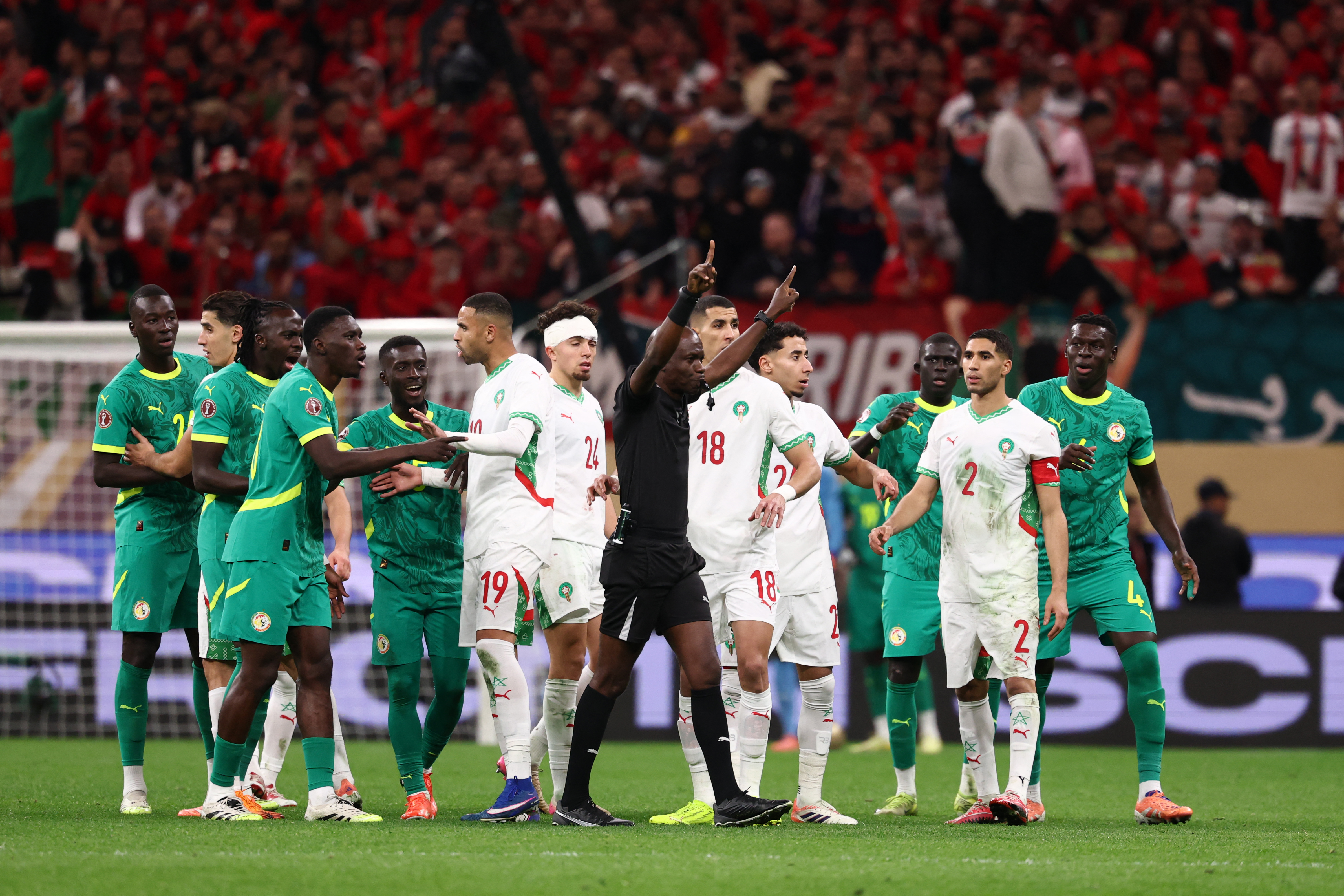 Congolese referee Jean-Jacques Ndala Ngambo calls for a VAR decision during the Africa Cup of Nations final football match between Senegal and Morocco. (Photo by FRANCK FIFE / AFP via Getty Images)